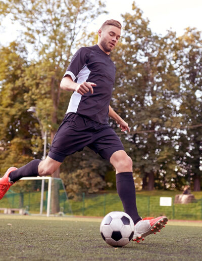 soccer player playing with ball on football field